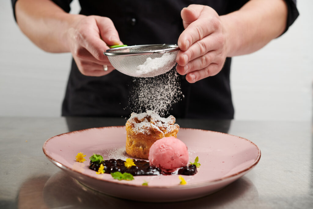 Koch des Parkhotel Neustadt richtet Dessert an
